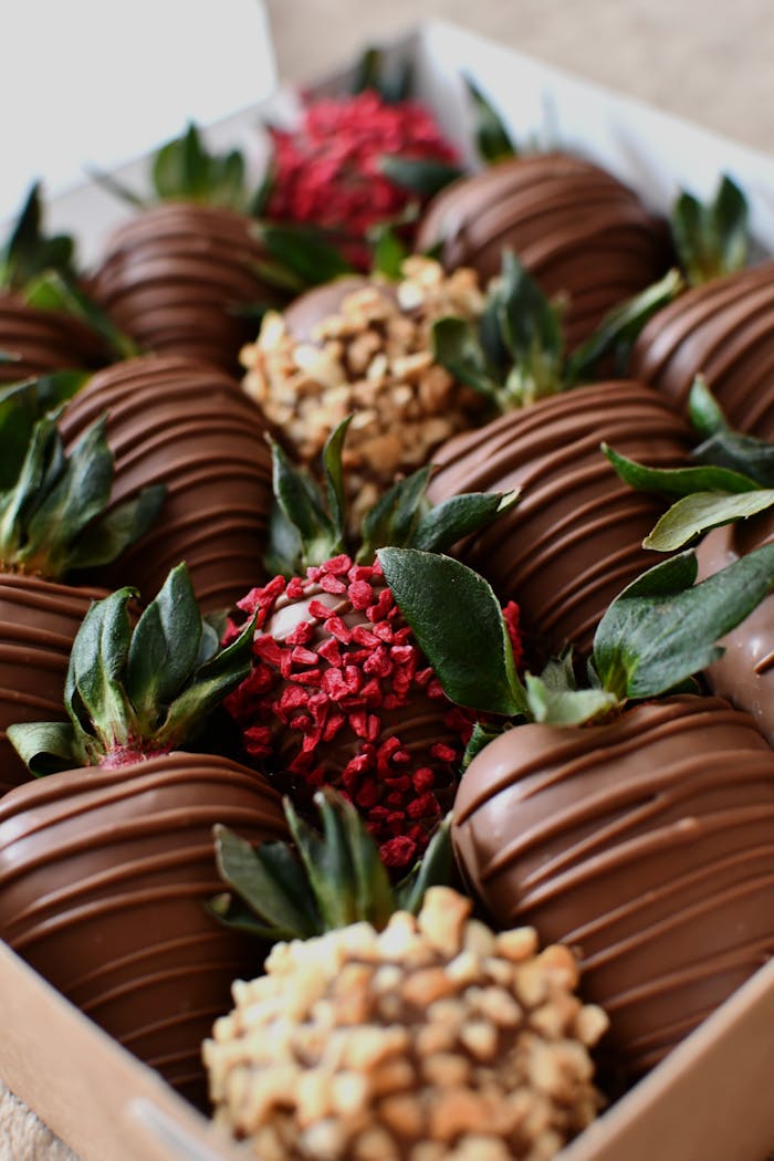 menu-03 Tempting chocolate-covered strawberries with assorted toppings in a box.