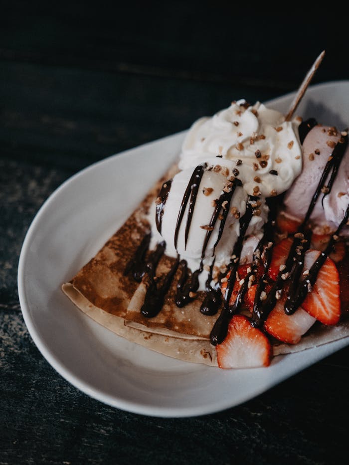 menu-04 Mouthwatering crêpes topped with fresh strawberries, ice cream, and chocolate sauce. Perfect for dessert photography.