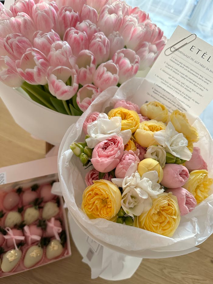 Vibrant arrangement of pink tulips and multicolored roses, perfect for celebrations.
