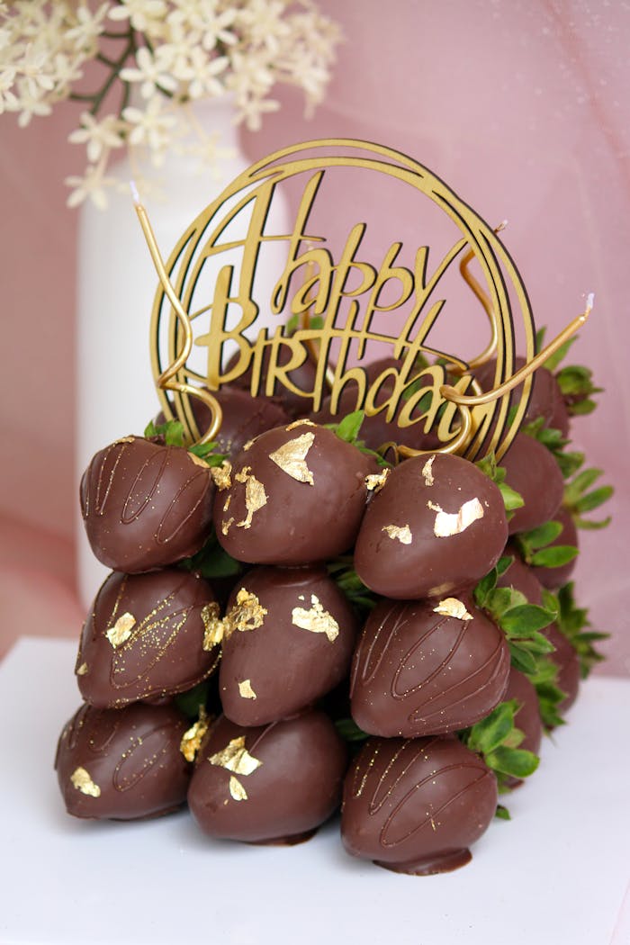 Delicious chocolate-covered strawberries with gold accents in a birthday themed display.