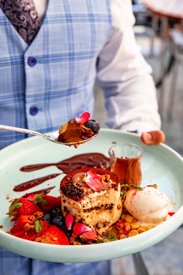 Delicious dessert with chocolate, fruits, and ice cream served elegantly on a plate.
